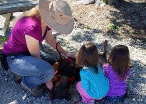 Laev lies on her back, twin toddlers rubbing her belly