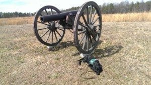 black lab puppy in service cape lying beside civil war cannon